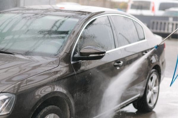 車の下回りを高圧洗浄機で洗浄している様子